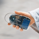 Square photo of a hand holding an air quality sensor.